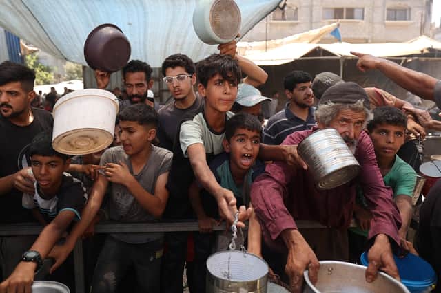 Children queue for food distributed by a charity kitchen at the Nuseirat refugee camp in the central Gaza Strip earlier this month (Picture: Eyad Baba)