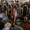 Palestinians queue to receive food at a charity kitchen in Khan Yunis in the southern Gaza Strip on Tuesday