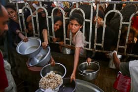 Palestinians queue to receive food at a charity kitchen in Khan Yunis in the southern Gaza Strip on Tuesday