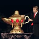 Donald Trump rubs a magic lamp during the opening ceremony for his Trump Taj Mahal casino in Atlantic City, New York in 1990. It closed in 2016 (Picture: Bill Swersey)