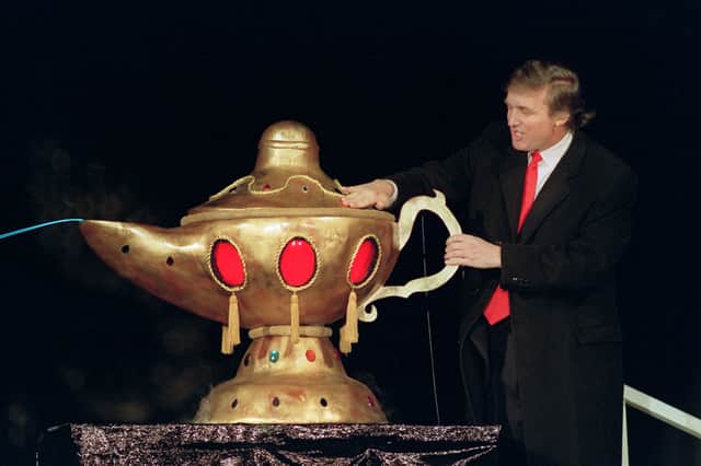 Donald Trump rubs a magic lamp during the opening ceremony for his Trump Taj Mahal casino in Atlantic City, New York in 1990. It closed in 2016 (Picture: Bill Swersey)