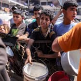 A boy, clearly in distress, queues for food in a charity kitchen in Gaza City earlier this month (Picture: Bashar Taleb)