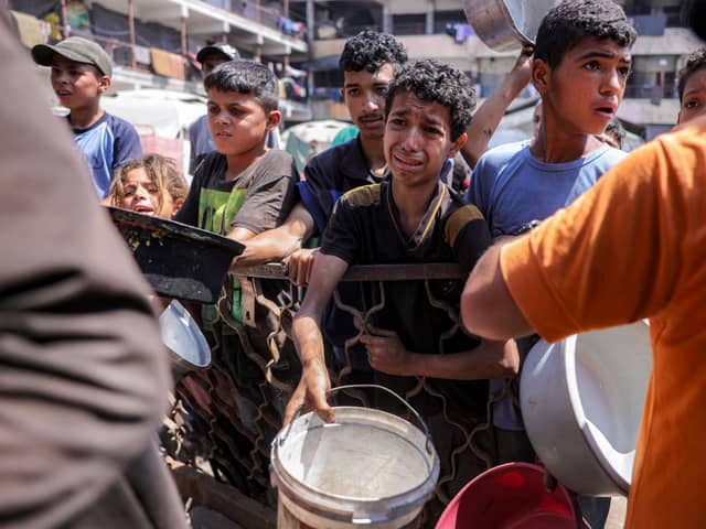 A boy, clearly in distress, queues for food in a charity kitchen in Gaza City earlier this month (Picture: Bashar Taleb)