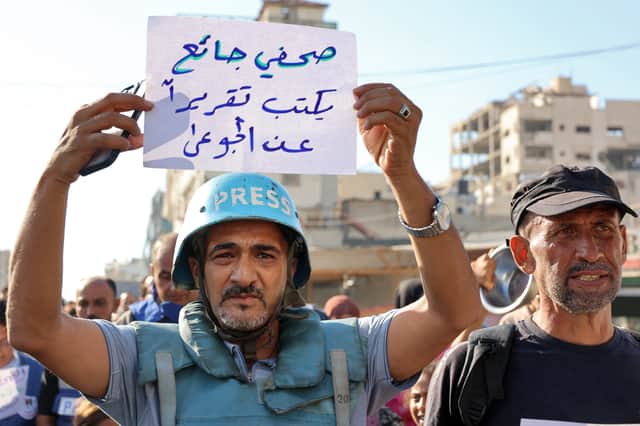 A man holds a sign saying 'a hungry journalist writes a report about the hungry' during a protest by journalists in Gaza City (Picture: Omar Al-Qattaa)