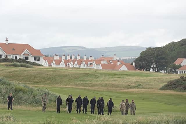 Police officers and members of the military doing a sweep before the US presidents showed up for a tour of his golf course on Saturday morning