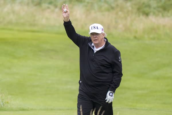 US President Donald Trump waves as he plays golf at his Trump Turnberry golf course in South Ayrshire