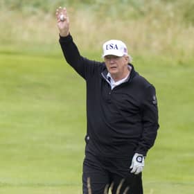 US President Donald Trump waves as he plays golf at his Trump Turnberry golf course in South Ayrshire