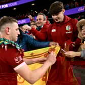 Scotland's Finn Russell signs a flag after the Lions overcame Australia.