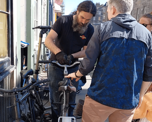 Dion Owen fixes a bike to be handed out to a Fringe performer.