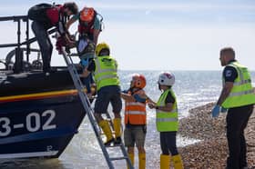 RNLI and Border Force staff help people disembark from a lifeboat after they were rescued in the English Channel (Picture: Dan Kitwood)