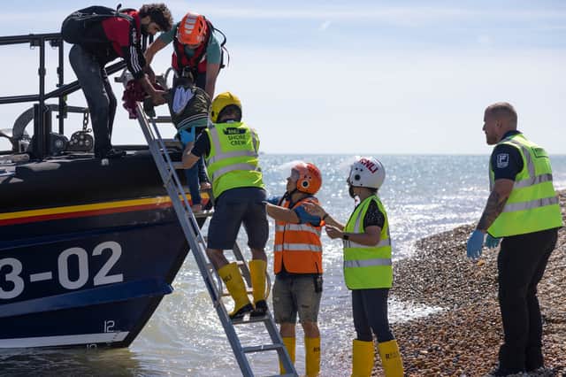 RNLI and Border Force staff help people disembark from a lifeboat after they were rescued in the English Channel (Picture: Dan Kitwood)