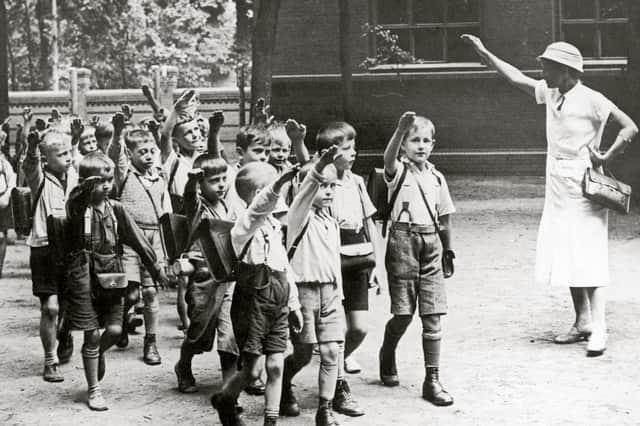 A teacher sees offer her pupils with a Hitler salute, which they return, in Germany around 1933 (Picture: Imagno)