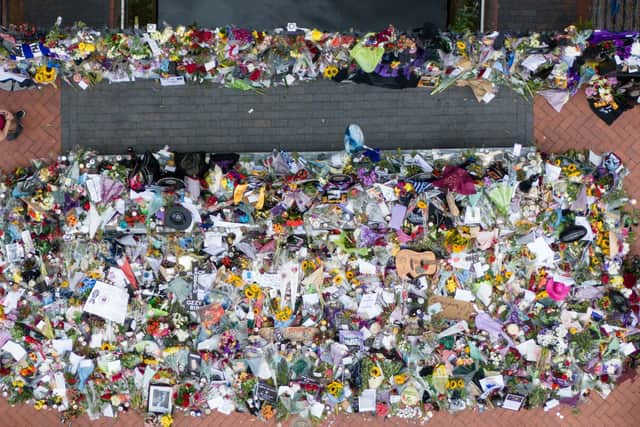 A woman observes floral tributes that are left on the Black Sabbath Bridge bench on Broad Street in Birmingham, following the death of Black Sabbath frontman Ozzy Osbourne aged 76. Picture: Jacob King/PA Wire