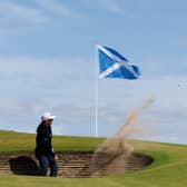 Ewen Ferguson of Scotland plays from a greenside bunker at the ninth hole during a practice round for the Nexo Championship at Trump International Golf Links 