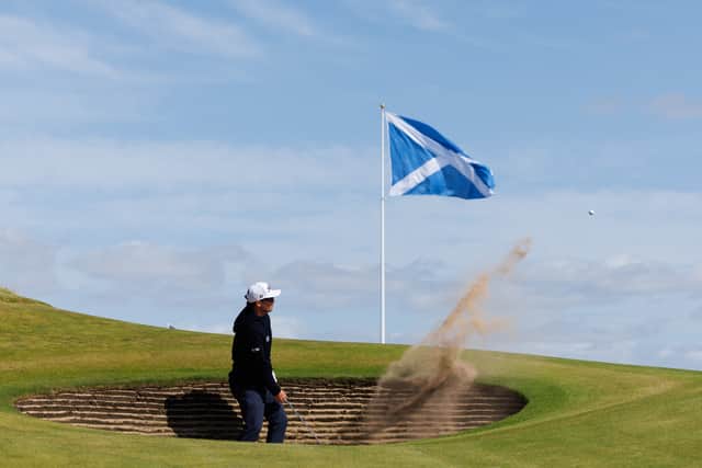 Ewen Ferguson of Scotland plays from a greenside bunker at the ninth hole during a practice round for the Nexo Championship at Trump International Golf Links