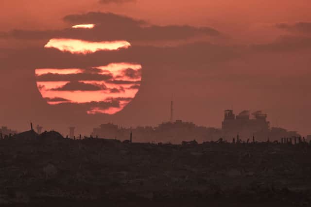 The sun sets behind buildings that were destroyed during the Israeli ground and air operations stand in the Gaza Strip as seen from southern Israel