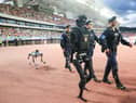 Police patrol with a humanoid robot and a robot dog during a football match between Wuxi and Huai'an in China