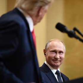 Vladimir Putin smiles at Donald Trump during a joint press conference in Helsinki in 2018 (Picture: Brendan Smialowski)