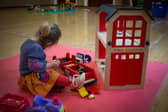 A young girl plays with toys at a playgroup for pre-school aged children 