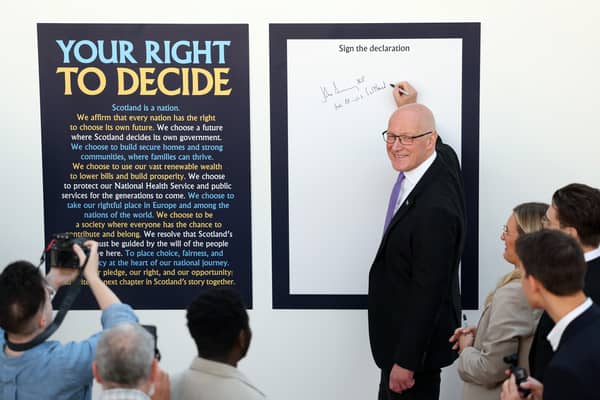 John Swinney signs a declaration after delivering a speech on Scotland's right to decide whether it should be an independent country (Picture: Jeff J Mitchell)