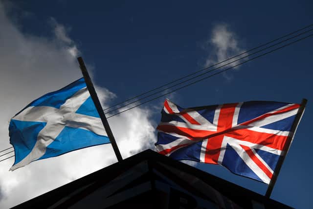 A saltire flag and Union Jack flutter in the wind.