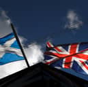 A saltire flag and Union Jack flutter in the wind.