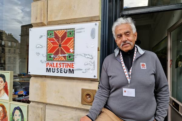Faisal Saleh, director of the Palestine Museum, next to his damaged sign.