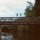 Young people taking the plunge to cool off in the River Spey on a warm summer's day.