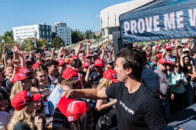 Charlie Kirk tosses MAGA hats as he arrives to speak at the University of Nevada in Reno during his "You're Being Brainwashed" tour in October last year