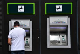A man takes money from a cash machine at a branch of Lloyds Bank. The banking group will close 49 branches across the UK between January and October 2026 (Photo: Carl Court/Getty Images)