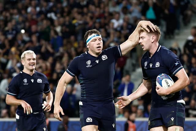 Scotland's fly-half Ben Healy, right, celebrates with teammates Hamish Watson, centre, and Darcy Graham, left, after scoring a try against Romania in Lille at the 2023 Rugby World Cup.