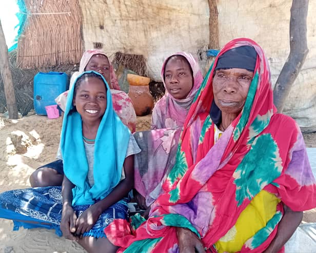 Naima and her daughters sit in the shade of the temporary shelter that is their home in Zabout camp.