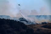 A helicopter drops water on a wildfire on the Isle of Bute in April this year (Picture: Jeff J Mitchell)