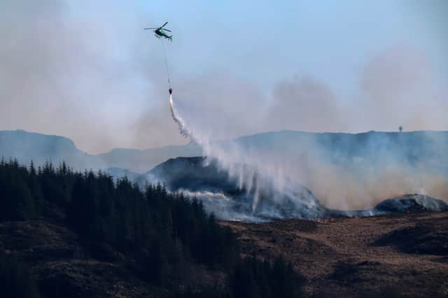 A helicopter drops water on a wildfire on the Isle of Bute in April this year (Picture: Jeff J Mitchell)