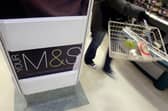 A shopper walks past a Marks and Spencer sign at a store at Covent Garden, London. M&S staff must work Boxing Day for the first time in five years (Photo: CARL DE SOUZA/AFP via Getty Images)