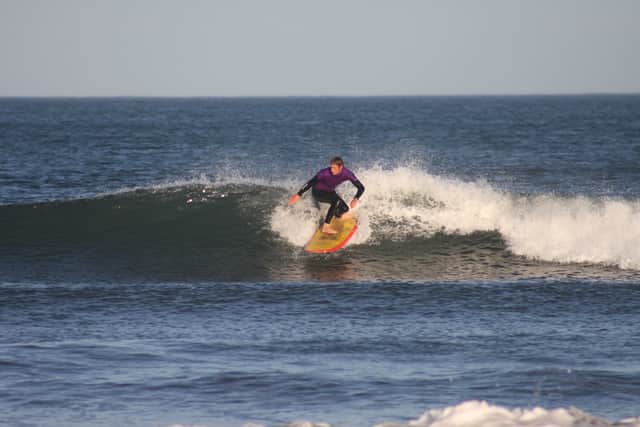 Tim Christopherson rides a wave at Belhaven Bay near Dunbar