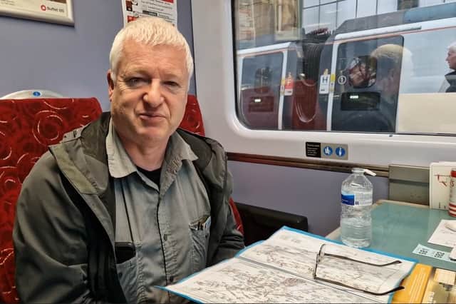 Simon Mortimer explaining "track bashing" with his rail map aboard the charter train