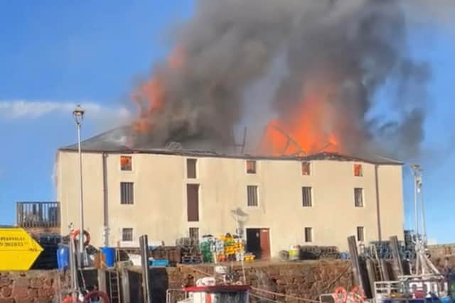 Onlookers watched as smoke and flames billowed from the building on Monday afternoon