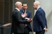 John Swinney speaking to special advisers Ewan Crawford and Colin McAllister (right) at the Scottish Parliament in Edinburgh
