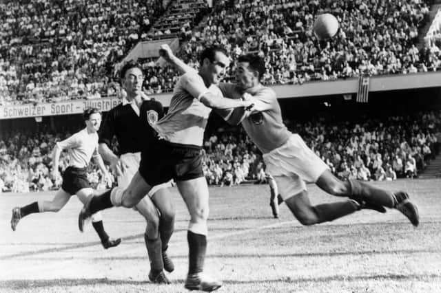 Omar Oscar Miguez of Uruguay reaches the ball first ahead of Frank Martin of Scotland but can only watch as his header goes over the bar during the FIFA World Cup Finals match played in Basel, Switzerland, 1954.