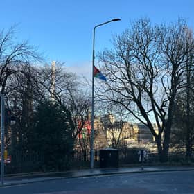 A 'solidarity Palestine Saltire' flag attached to a lamppost at the top of The Mound in Edinburgh