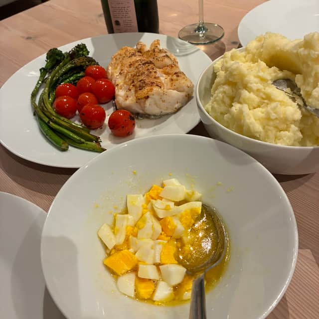 Cod from Bergen fish market served Norwegian style, simply with cherry tomatoes and broccoli, alongside eggs and mashed potatoes.