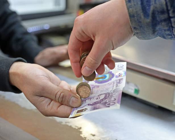 A customer pays for goods inside a shop. Christmas and New Year bank holidays can change when benefit payments are made in Scotland (Photo: SUSANNAH IRELAND/AFP via Getty Images)