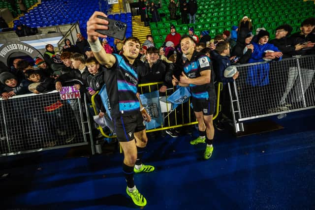 Glasgow Warriors' Jamie Dobie (L) and George Horne (R) take a photo with fans after the stunning win over Stade Toulousain at Scotstoun.