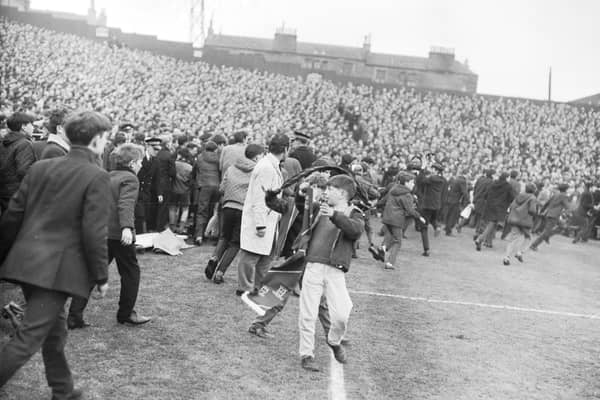 Police are swamped by supporters invading the pitch at Tynecastle Park during the Hearts versus Celtic match in March 1966.