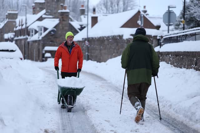 People clear snow from the roads and pavements in Huntly on Monday