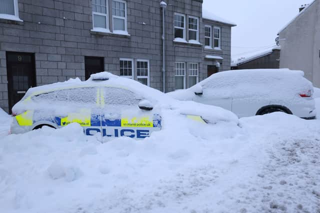 Police cars covered in snow in Huntly on Monday