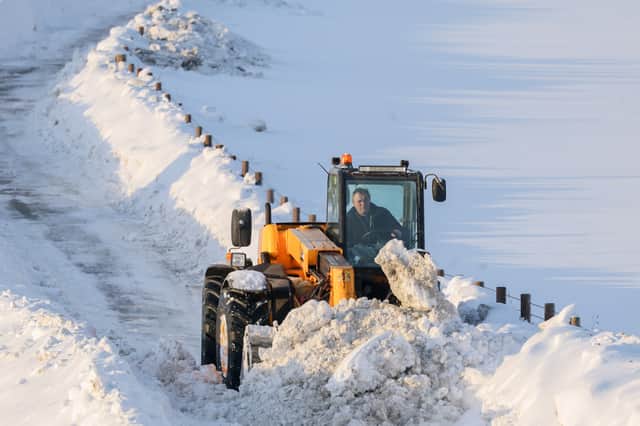 A man clears snow from a road with a digger near Gartly, Aberdeenshire, on Tuesday