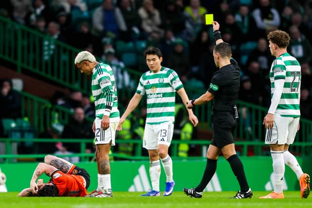 Referee Nick Walsh shows a yellow card to Celtic's Julian Araujo after a tackle on Dundee United's Will Ferry. (Photo by Craig Foy / SNS Group)