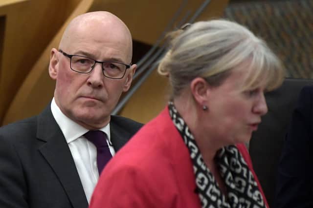 First Minister John Swinney listens to Finance Secretary Shona Robison announcing the draft Budget for 2026/27